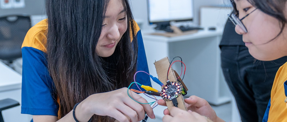 2 Invictus Students working on robotics project
