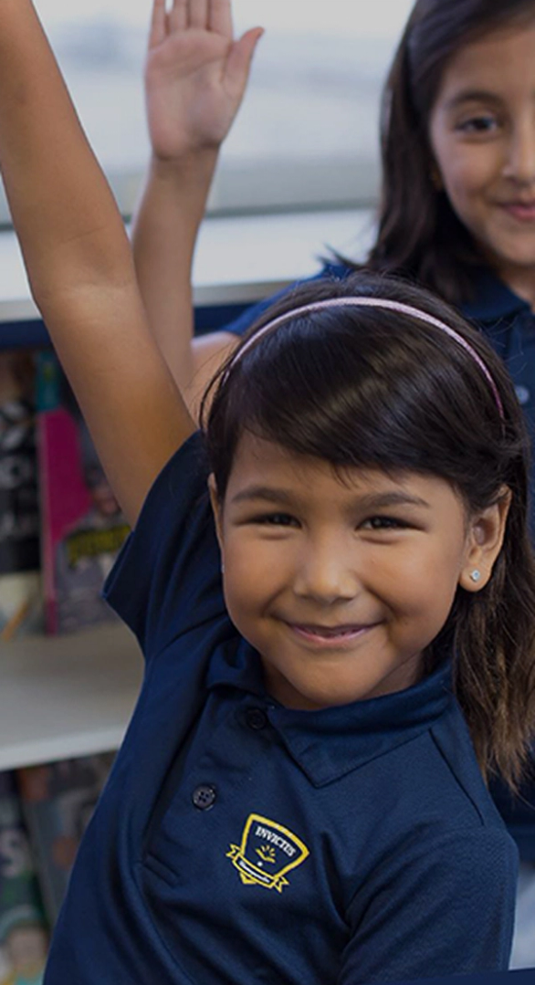 Invictus student smiling and raising hand