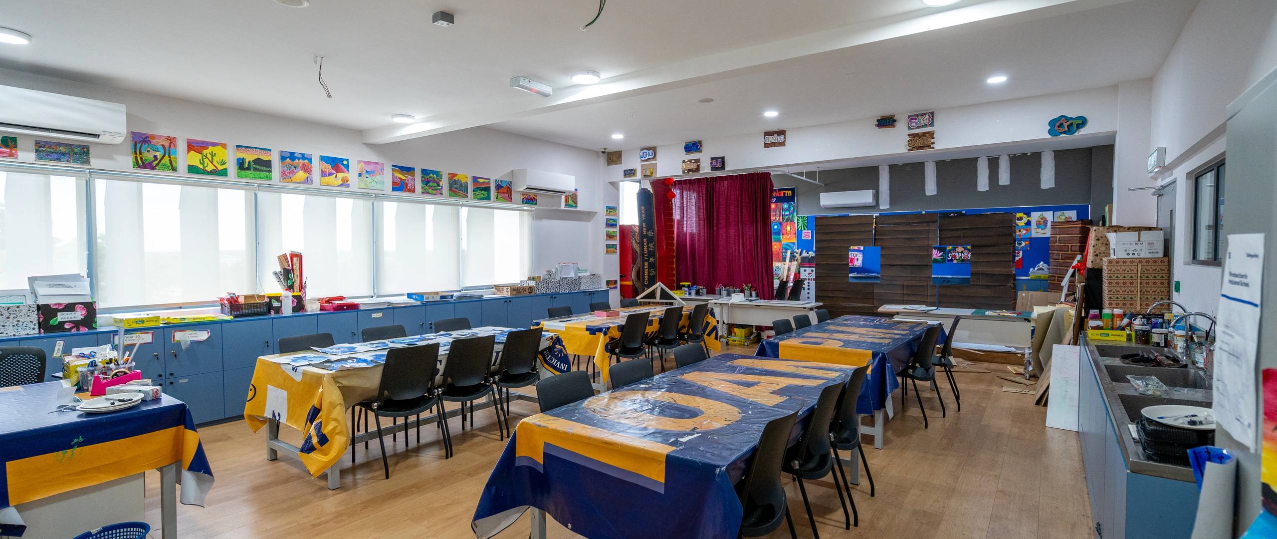 Art room with student artworks, large tables, and creative learning space.