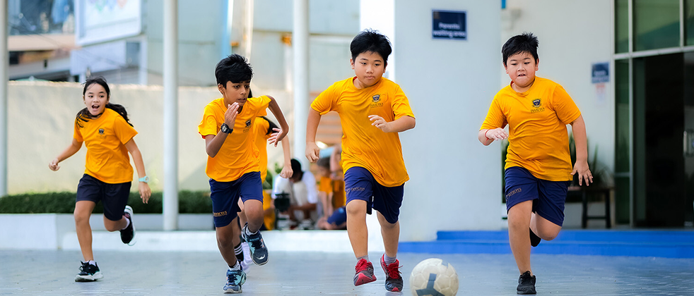 Students playing football and chasing the ball