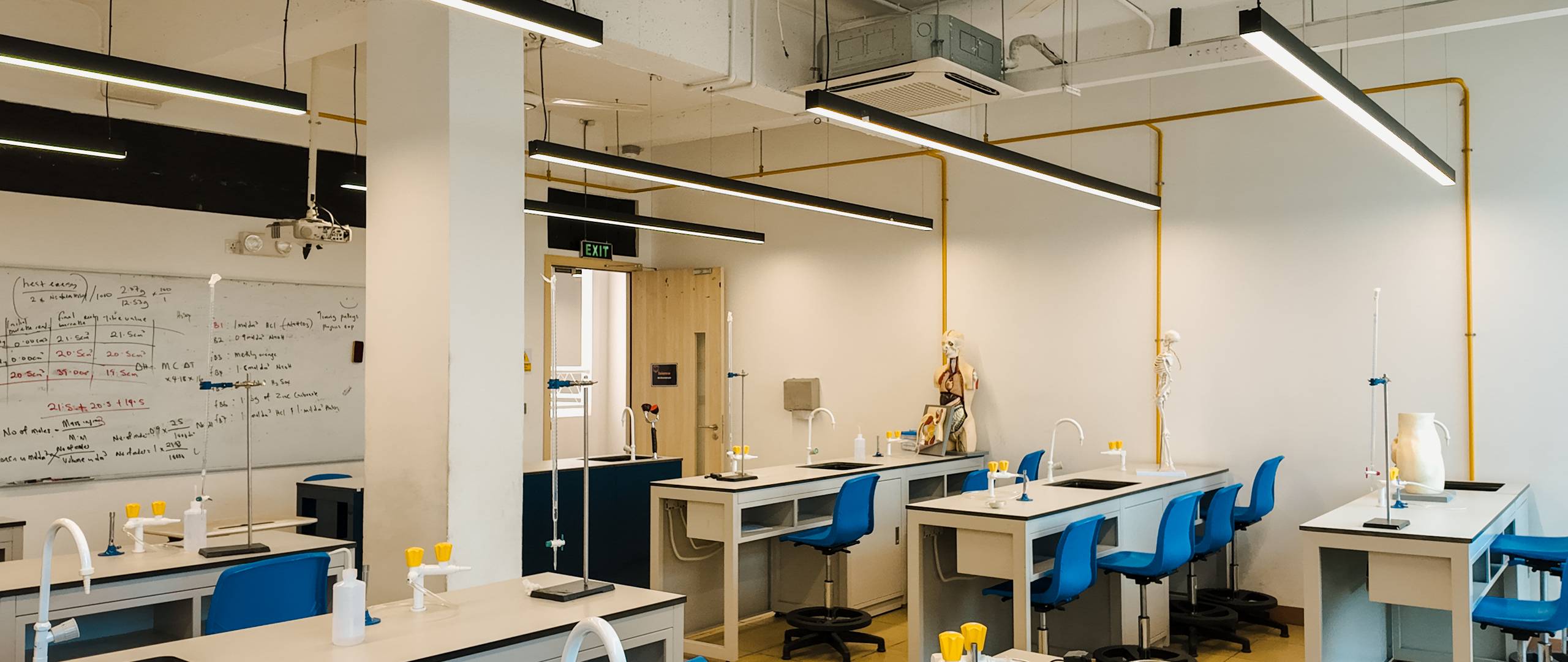 Well-equipped secondary science laboratory with lab sinks, blue chairs, and modern fixtures at Invictus Phnom Penh campus.