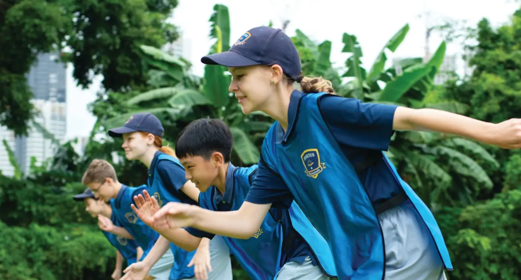 Close-up of two boys in Invictus sports polos sprinting side by side outdoors, their expressions focused and determined.