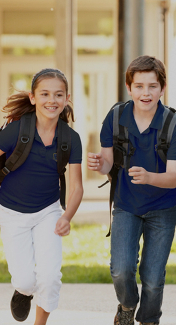 Invictus students happily running towards camera with backpack