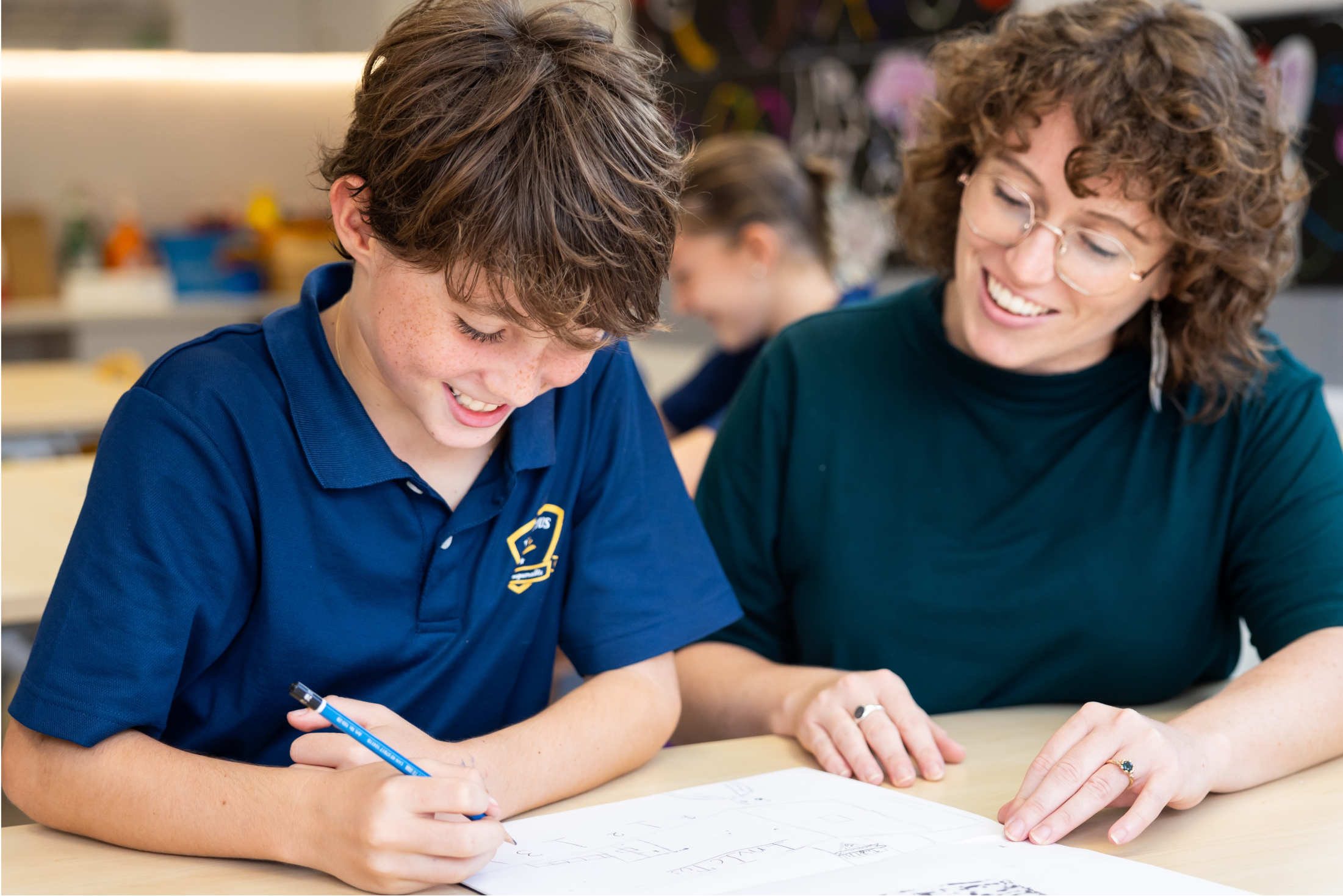 Student and teacher writing on paper