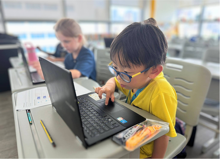  Young student focused on coding at a laptop during a tech-based ECA session at Invictus International School Malaysia.