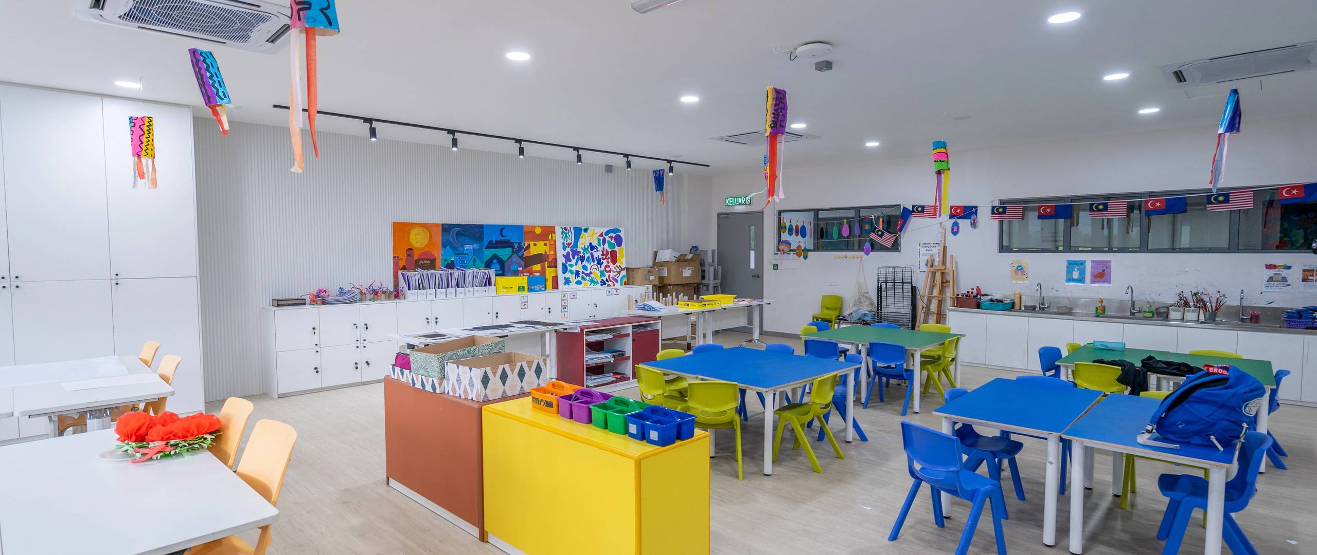 Colourful art classroom with creative student projects and craft tables.