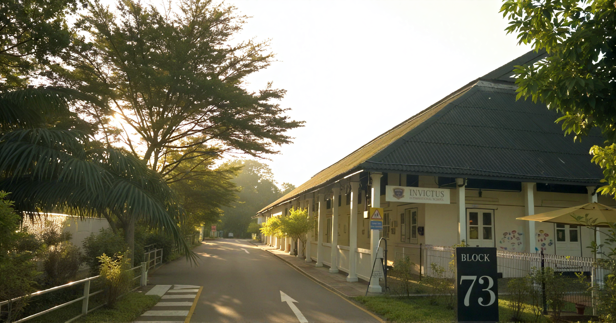 Morning sunlight casting on tree-lined entrance to Invictus International School Block 73.