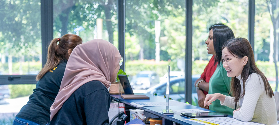 Warm and welcoming conversation between school staff and a parent at the Invictus admissions desk.