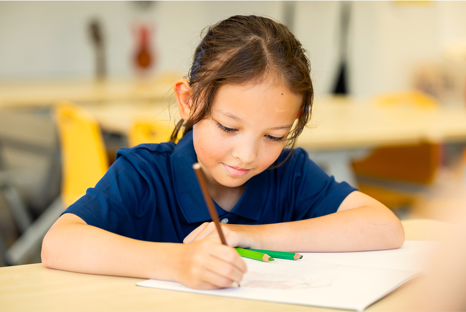 Art teacher engaging with two students during a drawing activity at Invictus Bukit Timah.