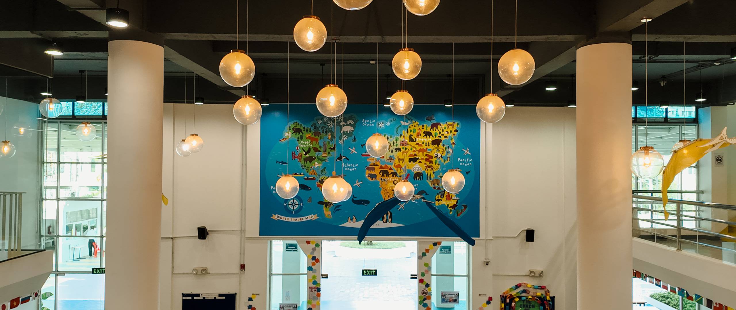 Invictus Phnom Penh’s central staircase with vibrant cushions for student seating, surrounded by contemporary architecture and creative lighting.
