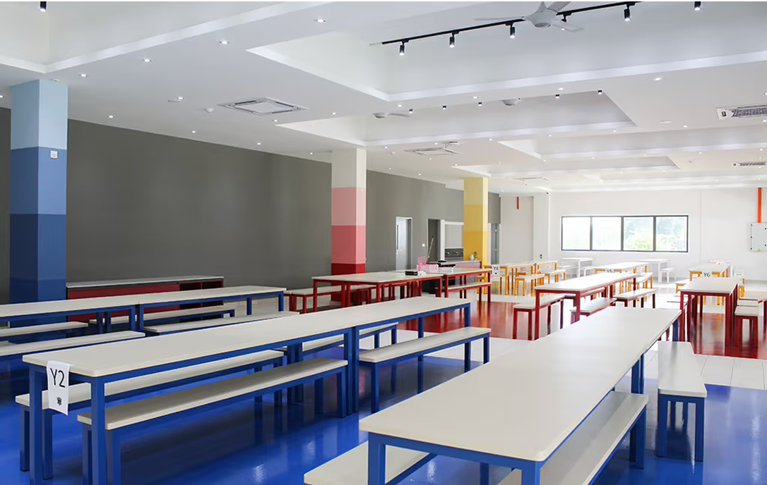 Bright and spacious cafeteria at Spring Hills Campus with colourful furniture and modern lighting, providing a welcoming dining space for students.