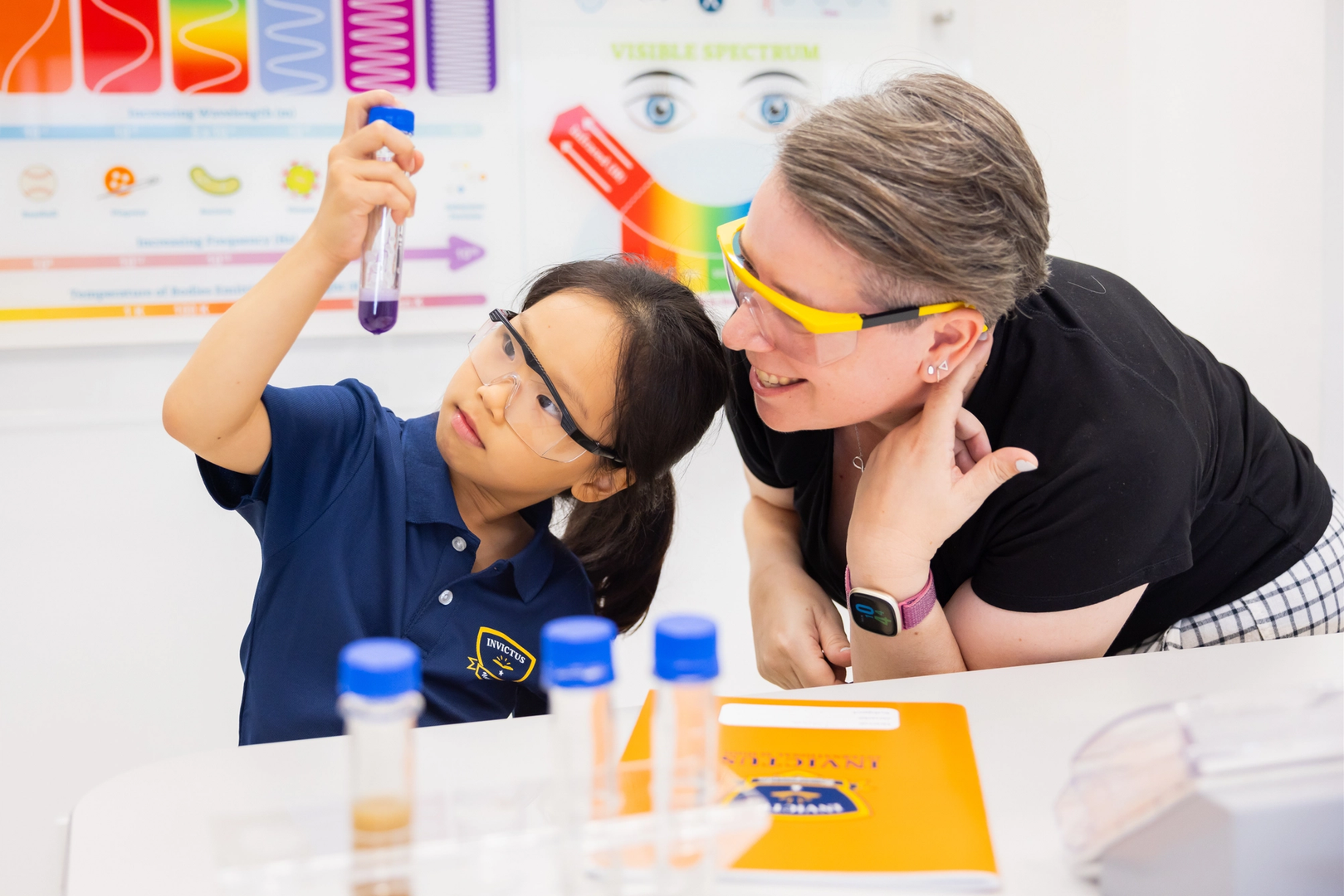 Chemistry teacher teaching a student holding a test tube