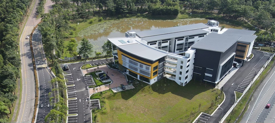 Aerial view of the Invictus International School campus surrounded by greenery, with modern facilities and ample parking.