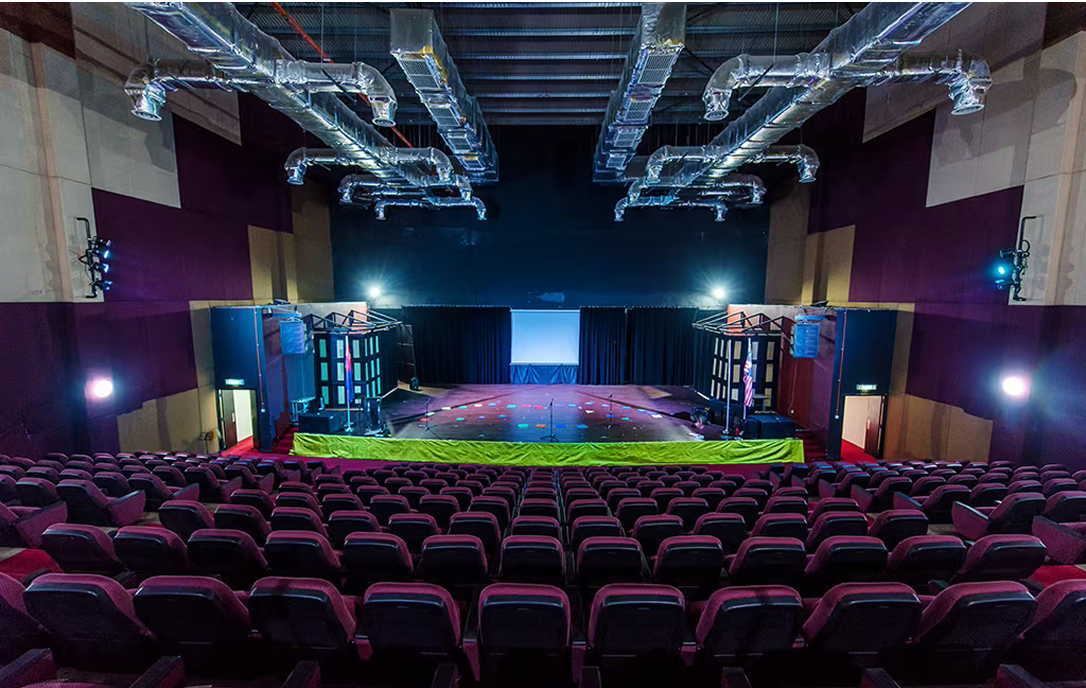 Professional-grade auditorium at Spring Hills Campus with tiered seating and a fully equipped stage for student performances and assemblies.