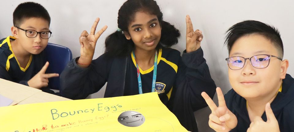 Close-up of two boys in Invictus sports polos sprinting side by side outdoors, their expressions focused and determined.