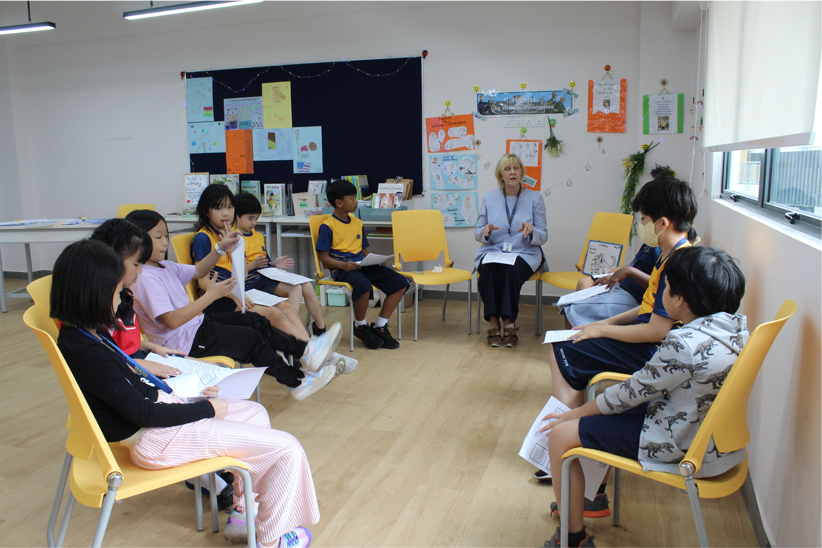 A teacher and student sitting on chairs in a circular formation, discussing.