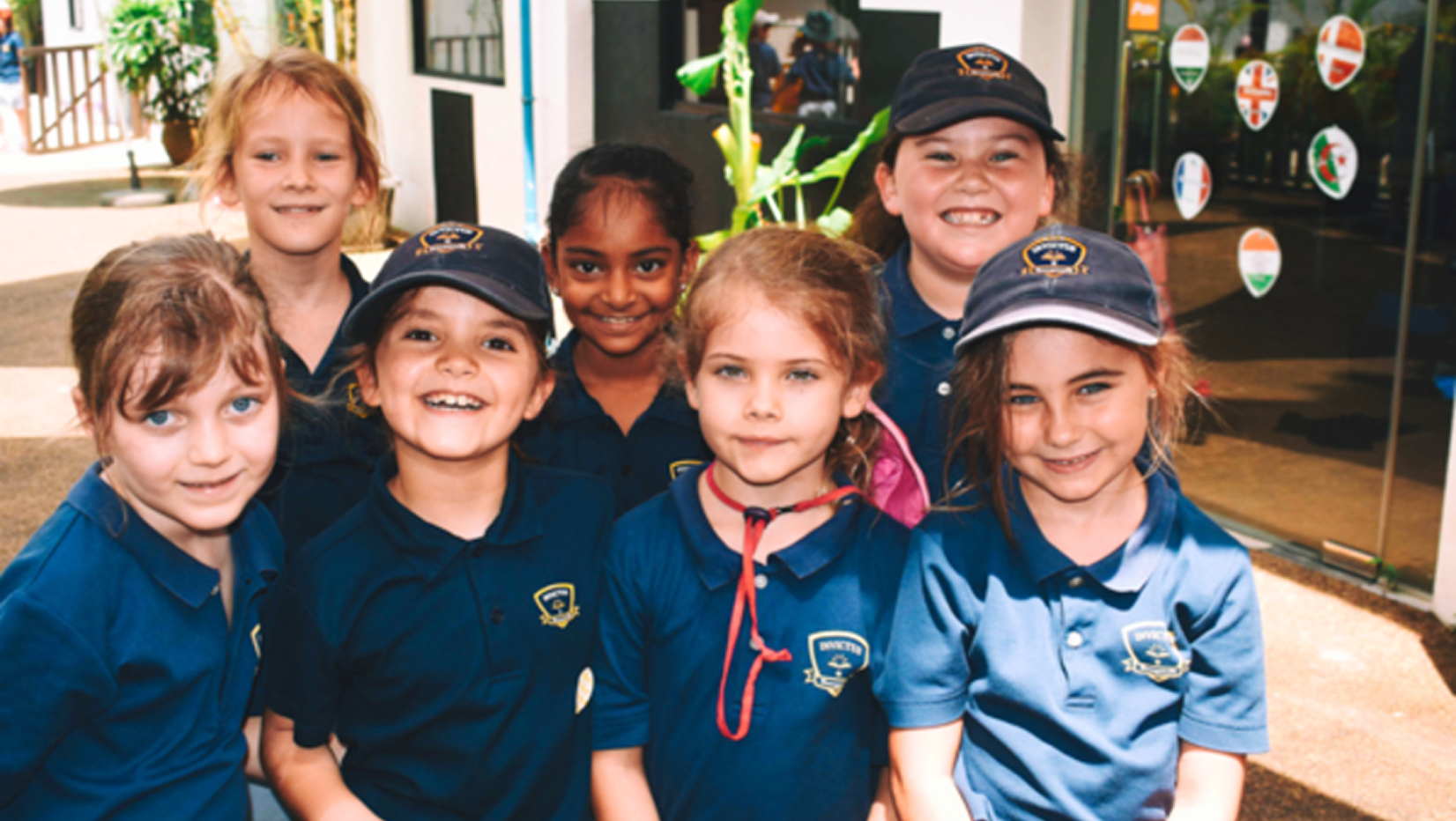 Seven Primary School Students with Invictus Uniforms Smiling at the Camera outdoors