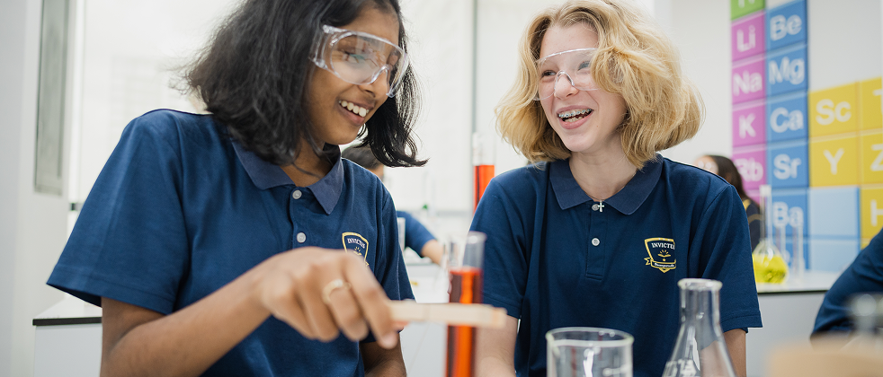 Invictus Singapore students engaging in a science experiment in the school laboratory.