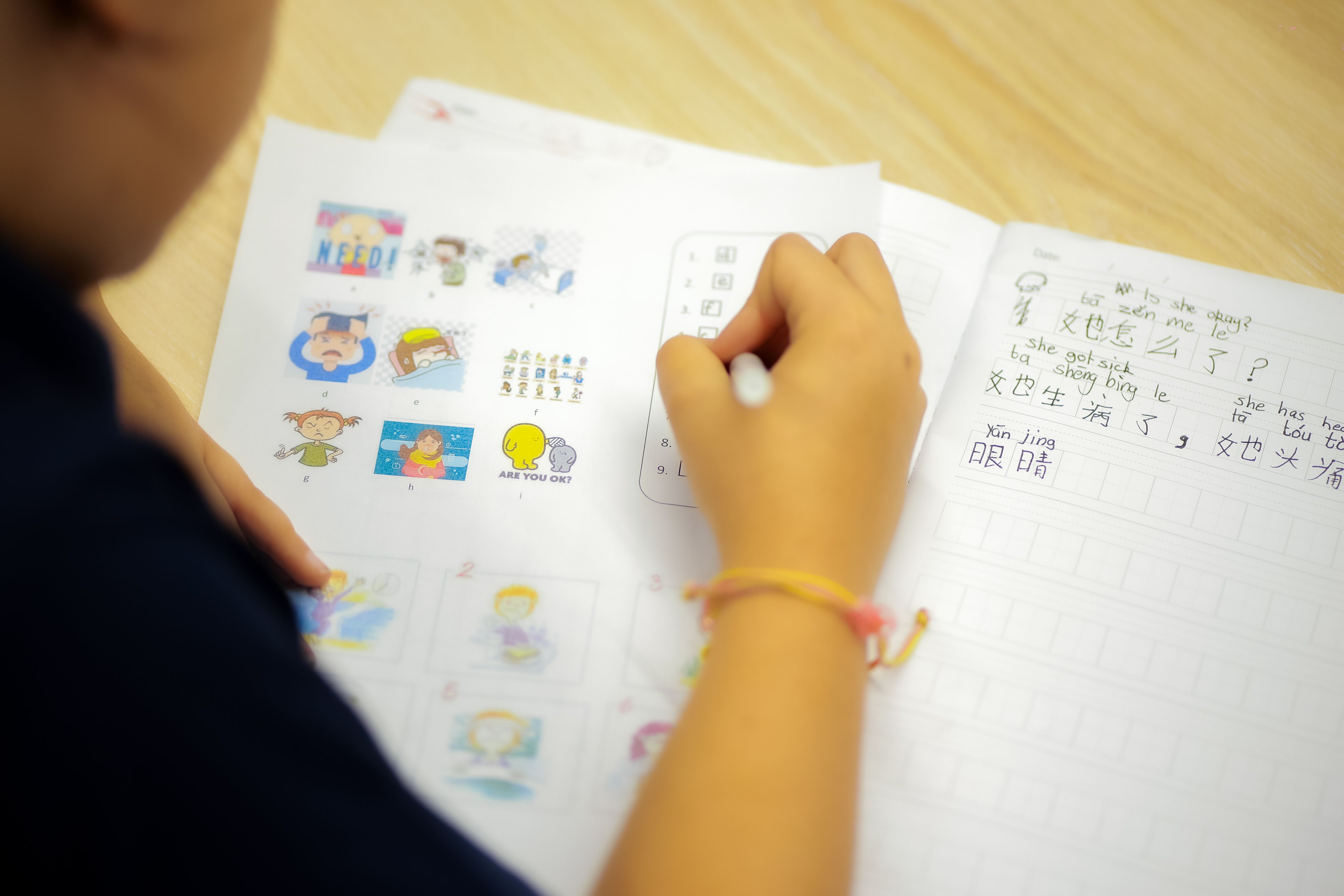 Two girls enjoying books inside a circular cushioned nook at Invictus Phnom Penh’s library, surrounded by brightly decorated bookshelves and learning resources.