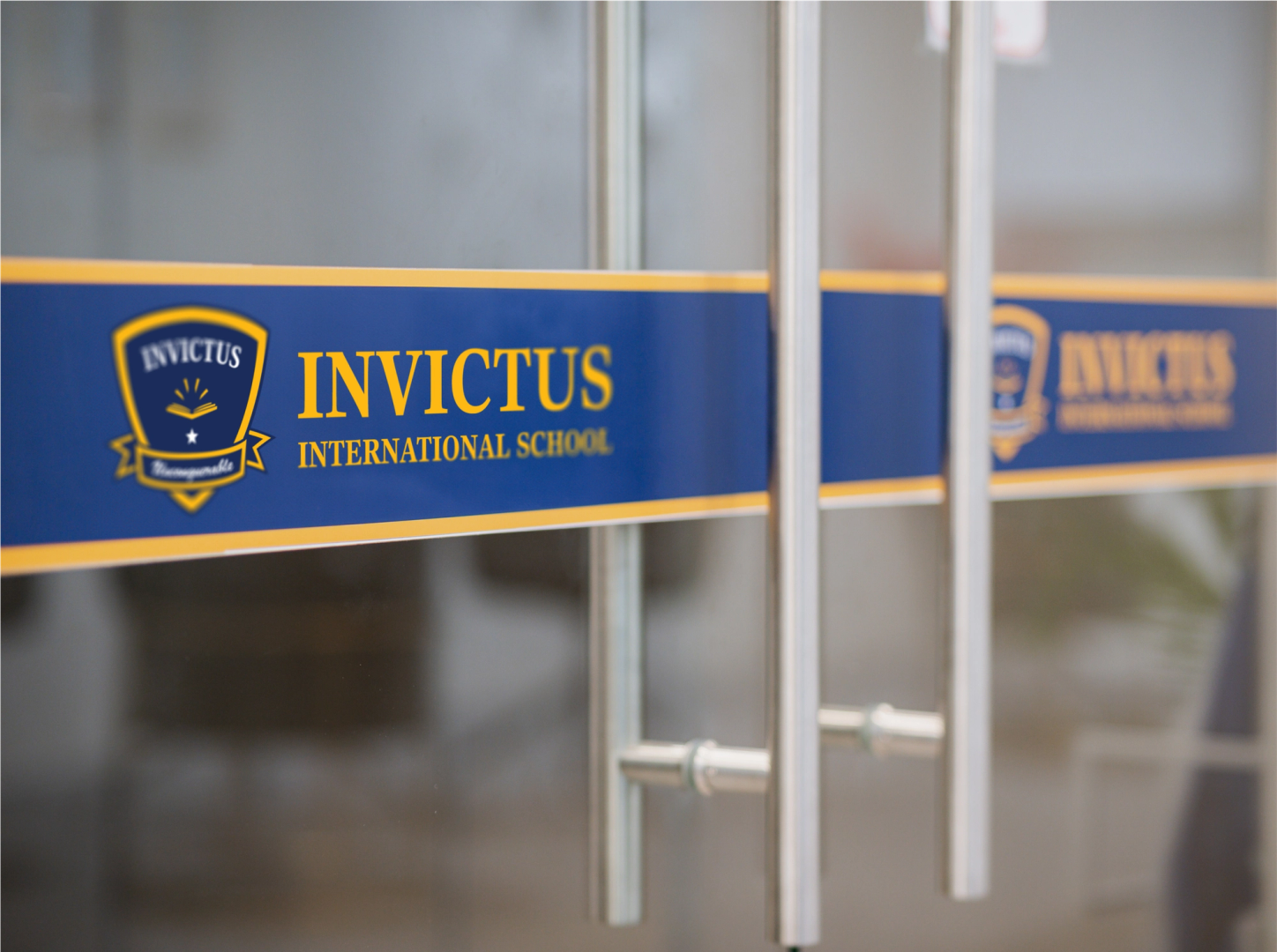 View of a glass door with the Invictus International School logo