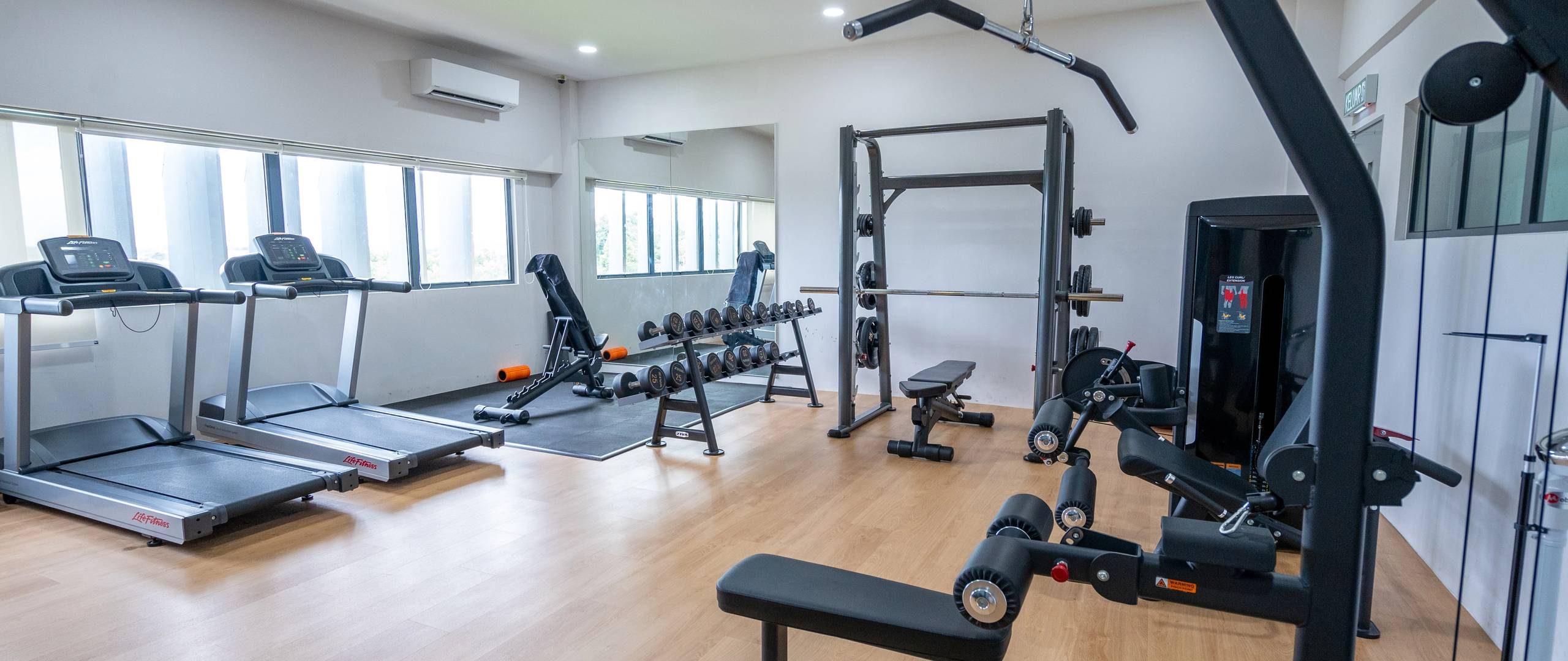 Gym with free weights and strength training equipment.