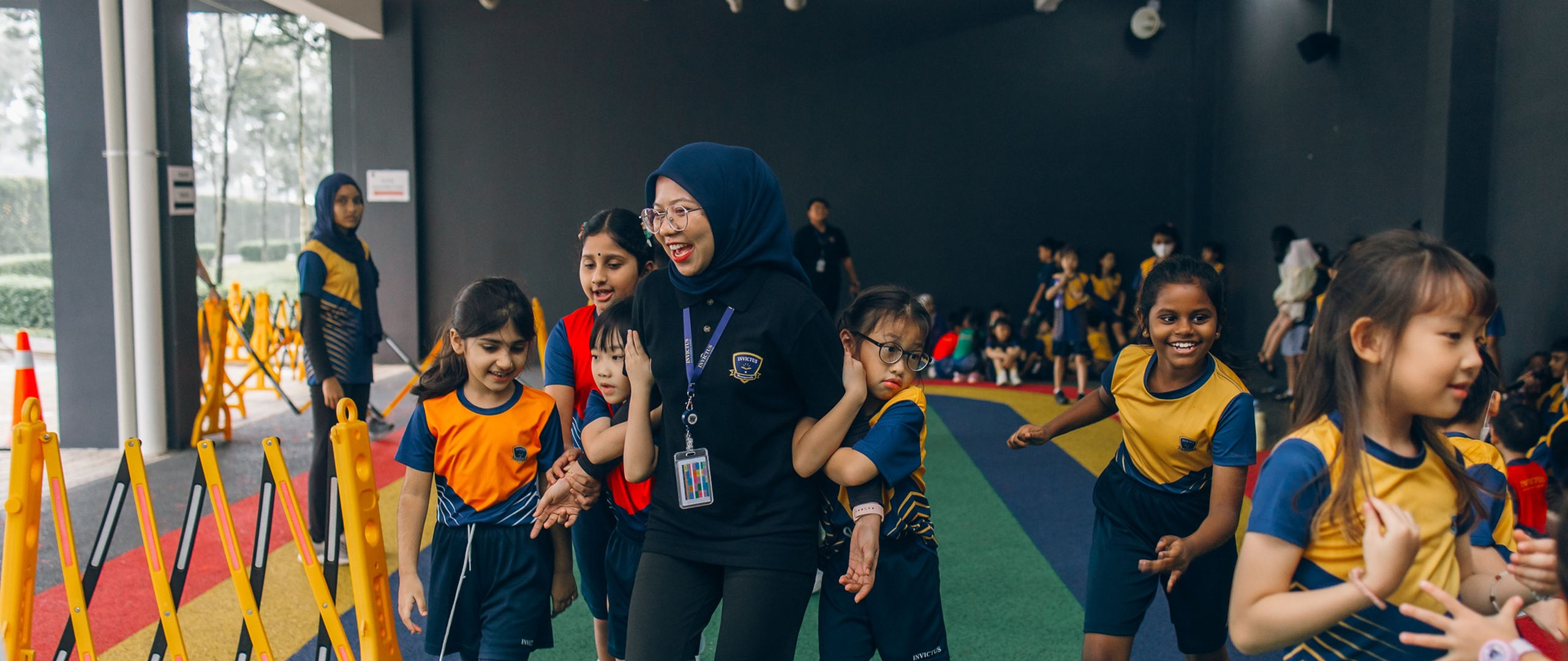Students at Invictus Horizon Hills Malaysia enjoying outdoor activities with teachers, reflecting the joyful and diverse spirit of the campus.