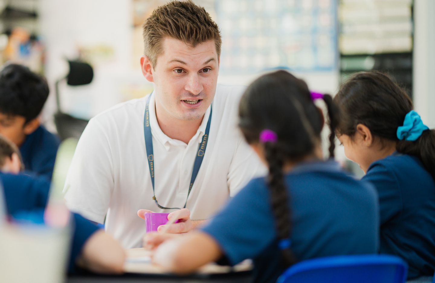 Teacher teaching two students