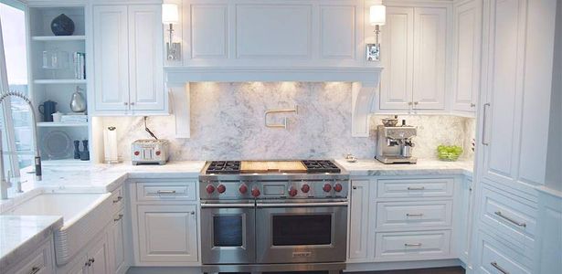 White kitchen with four seat island.