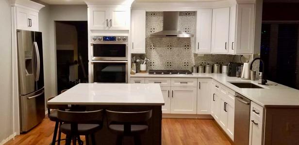 White kitchen with four seat island.