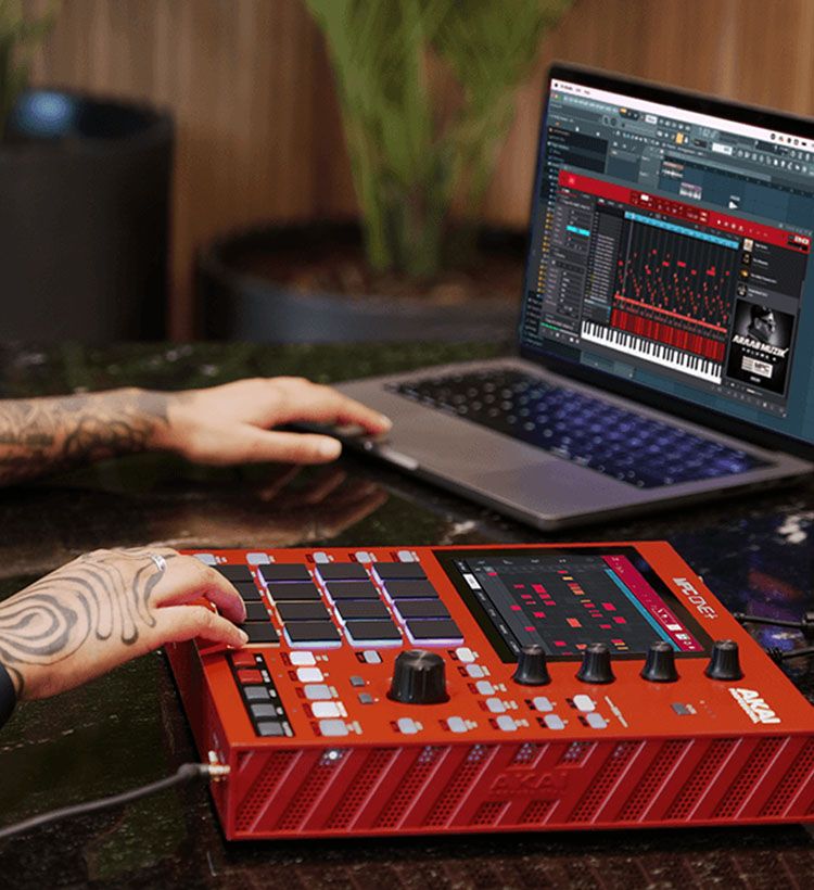 Tattooed hands using Akai sampler and laptop