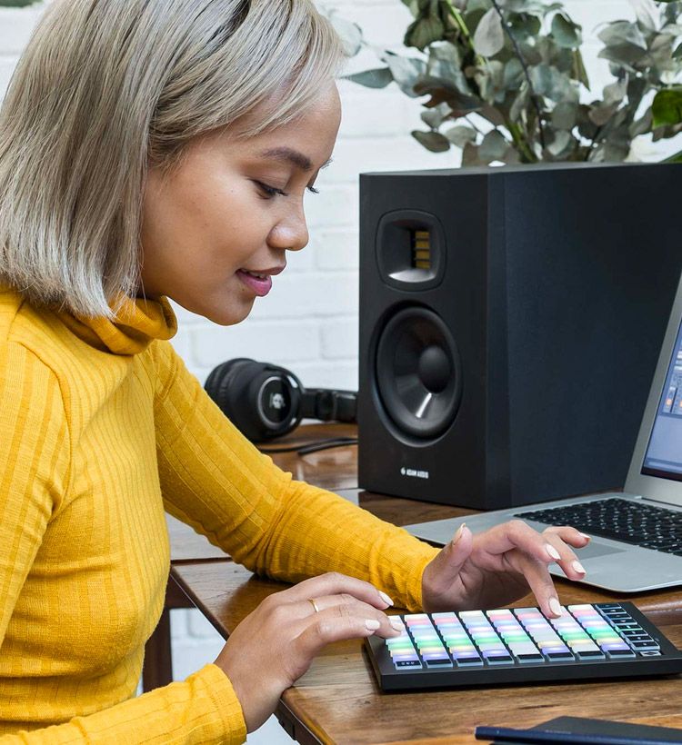 Young woman creating a song on a launchpad mini