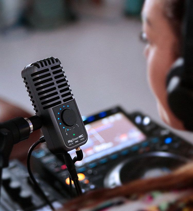 Over shoulder shot of girl singing into IK Multimedia microphone