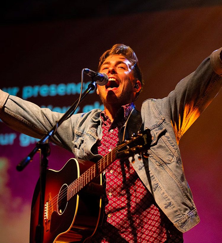 Man on stage singing into a dynamic microphone