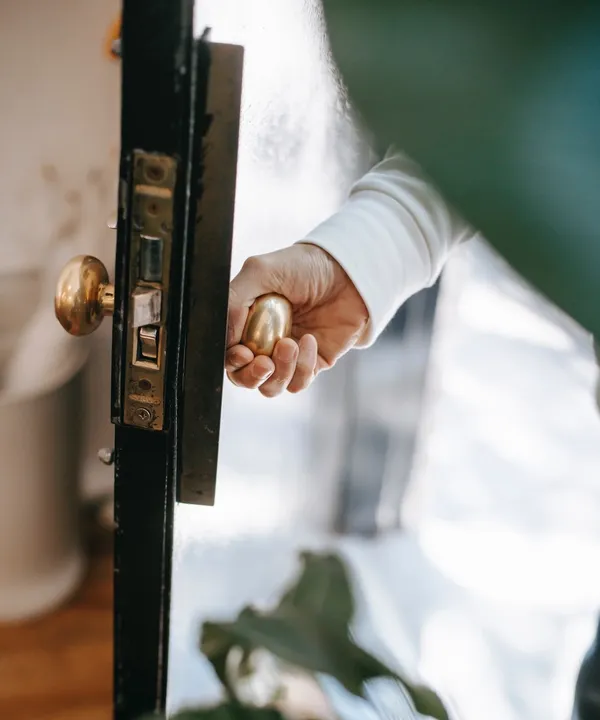Mann öffnet Tür am Türknauf