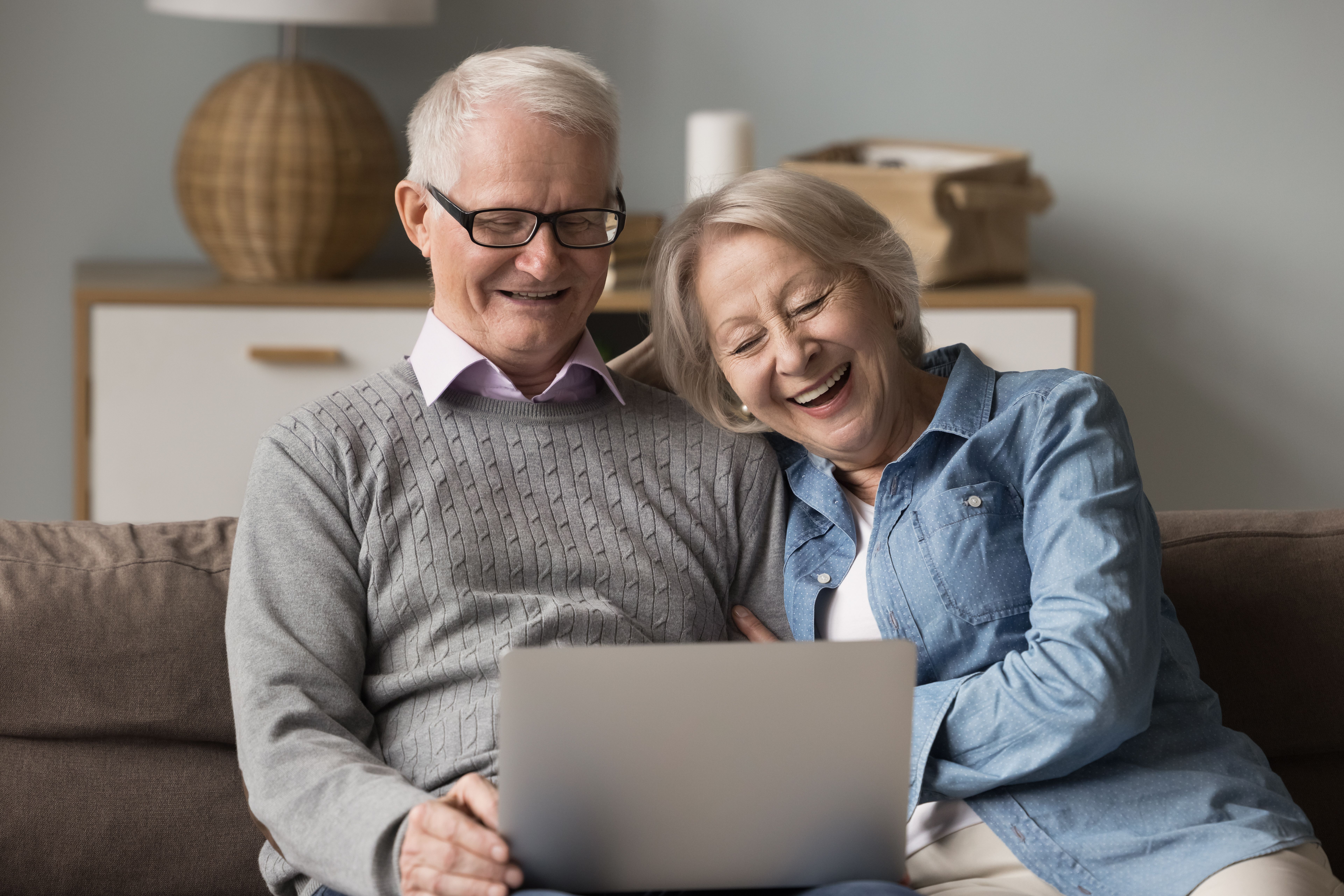 Older couple researching dental implant costs in the UK on a laptop at home