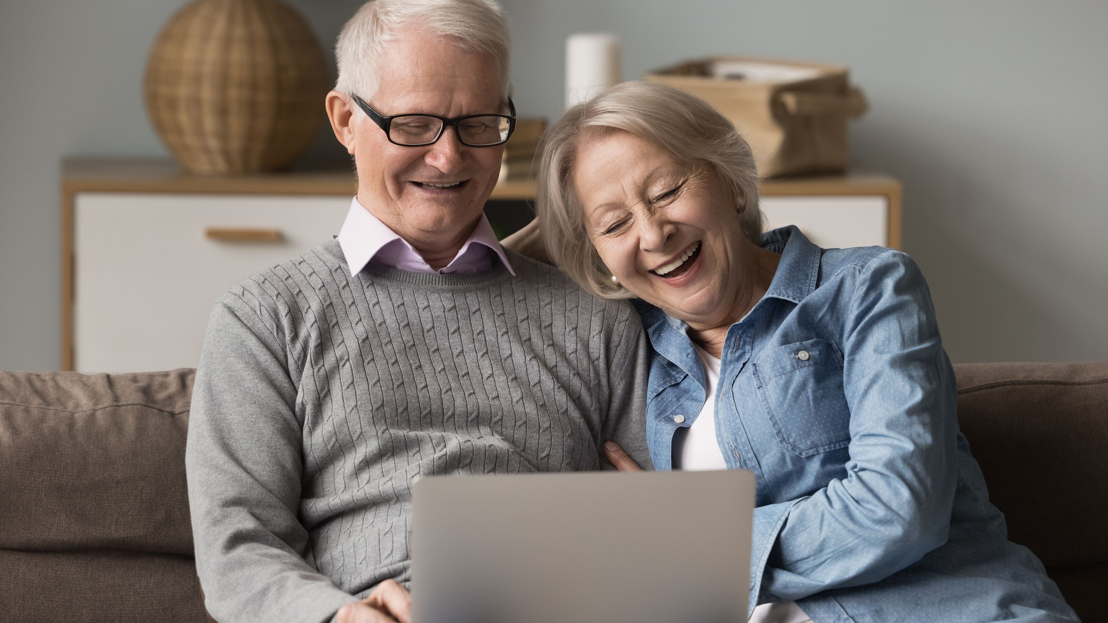 Older couple researching dental implant costs in the UK on a laptop at home