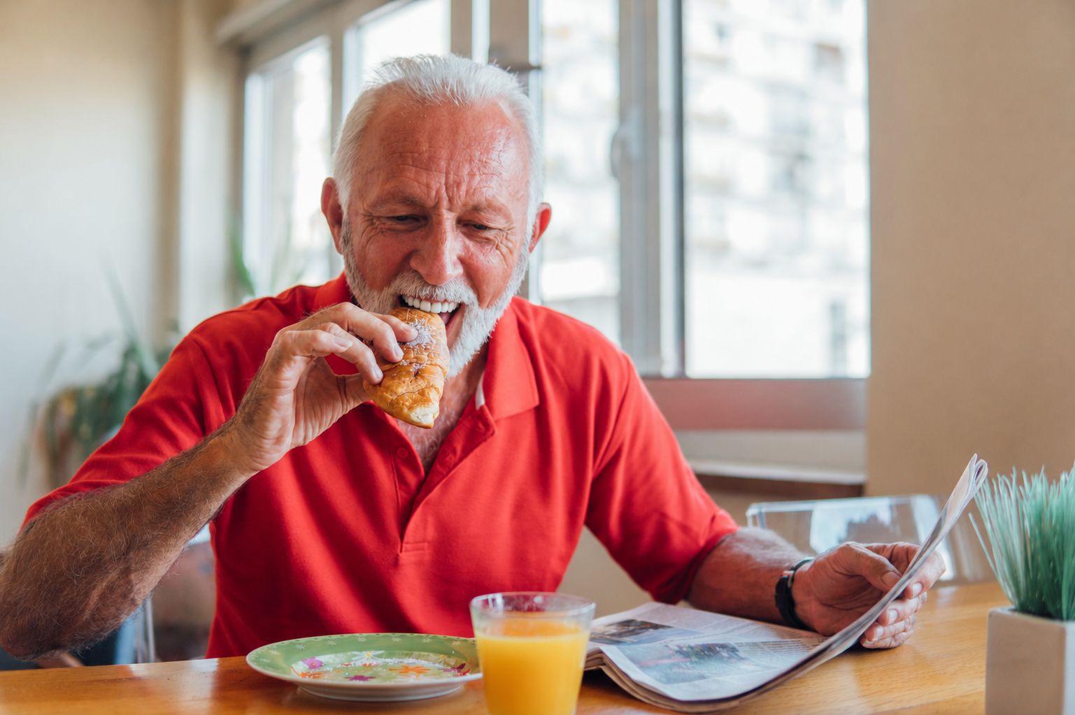 Smiling older man eating breakfast comfortably after researching dental implants on the NHS