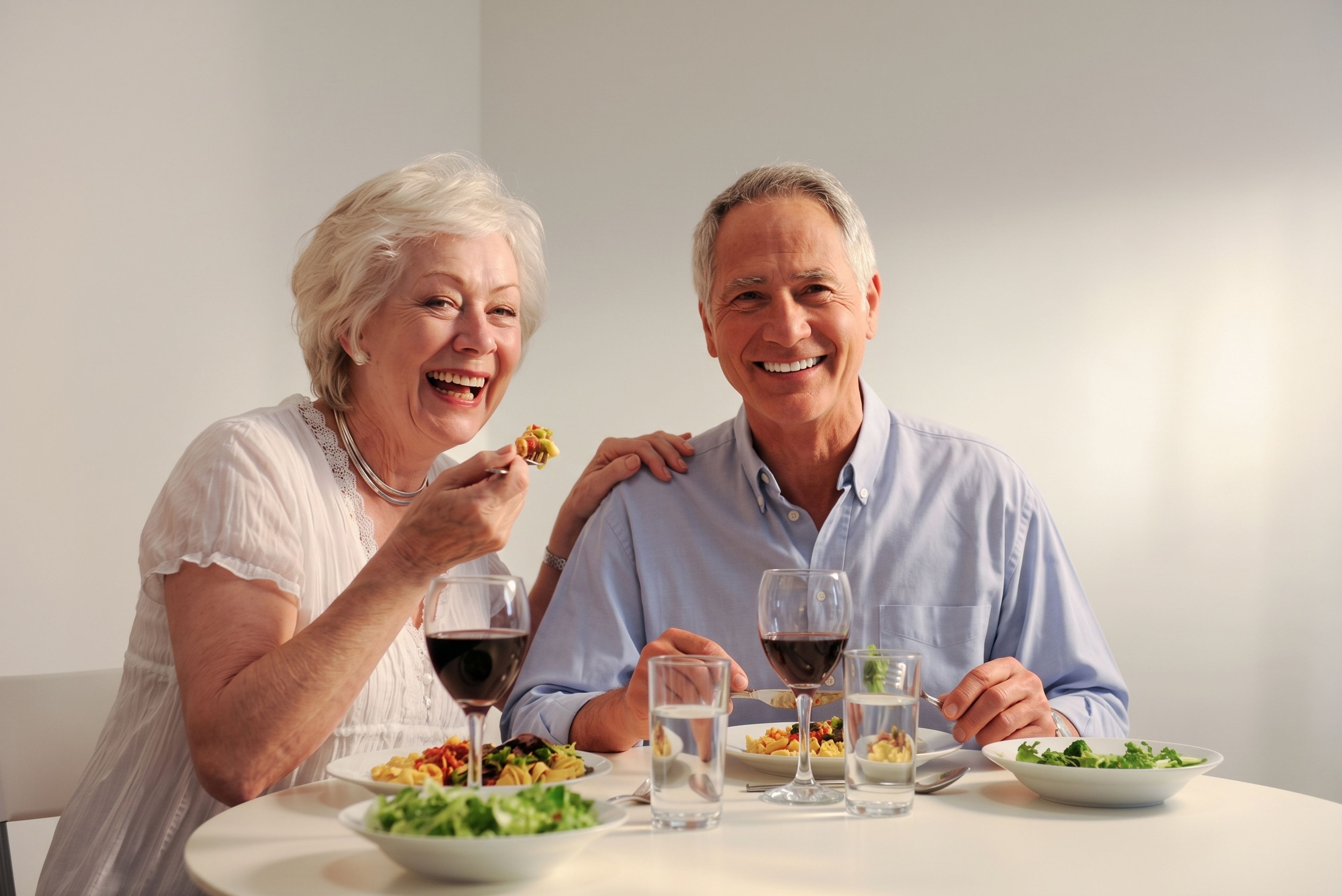 Older couple smiling over a meal, from Safe Smile Implants' guide to dental implant costs