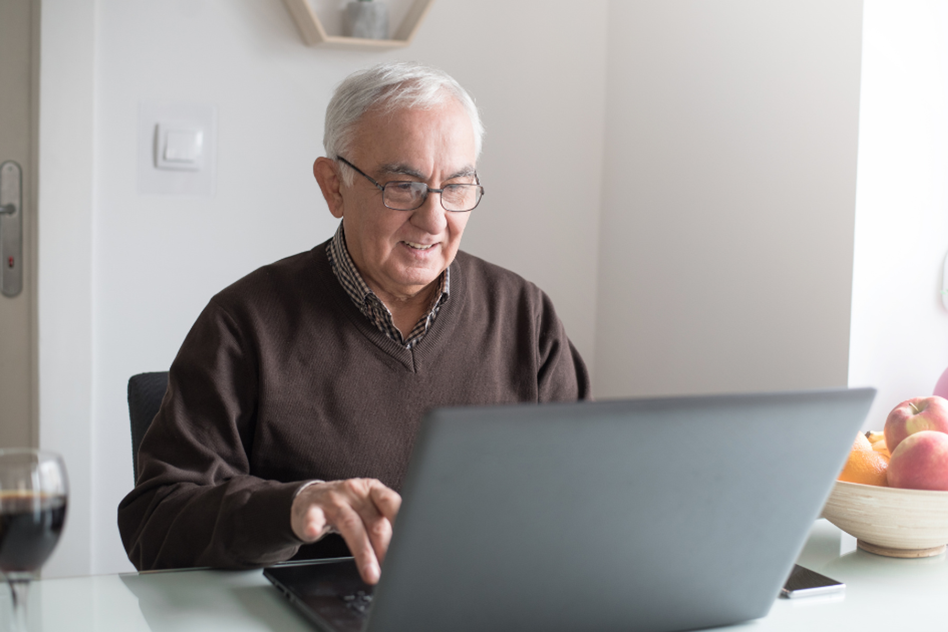 Man comparing dental implant quotes on a laptop at home ahead of a second opinion, Safe Smile Implants