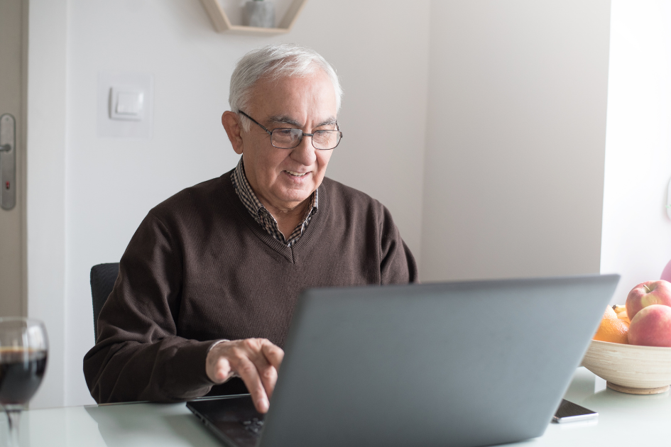 Man comparing dental implant quotes on a laptop at home ahead of a second opinion, Safe Smile Implants