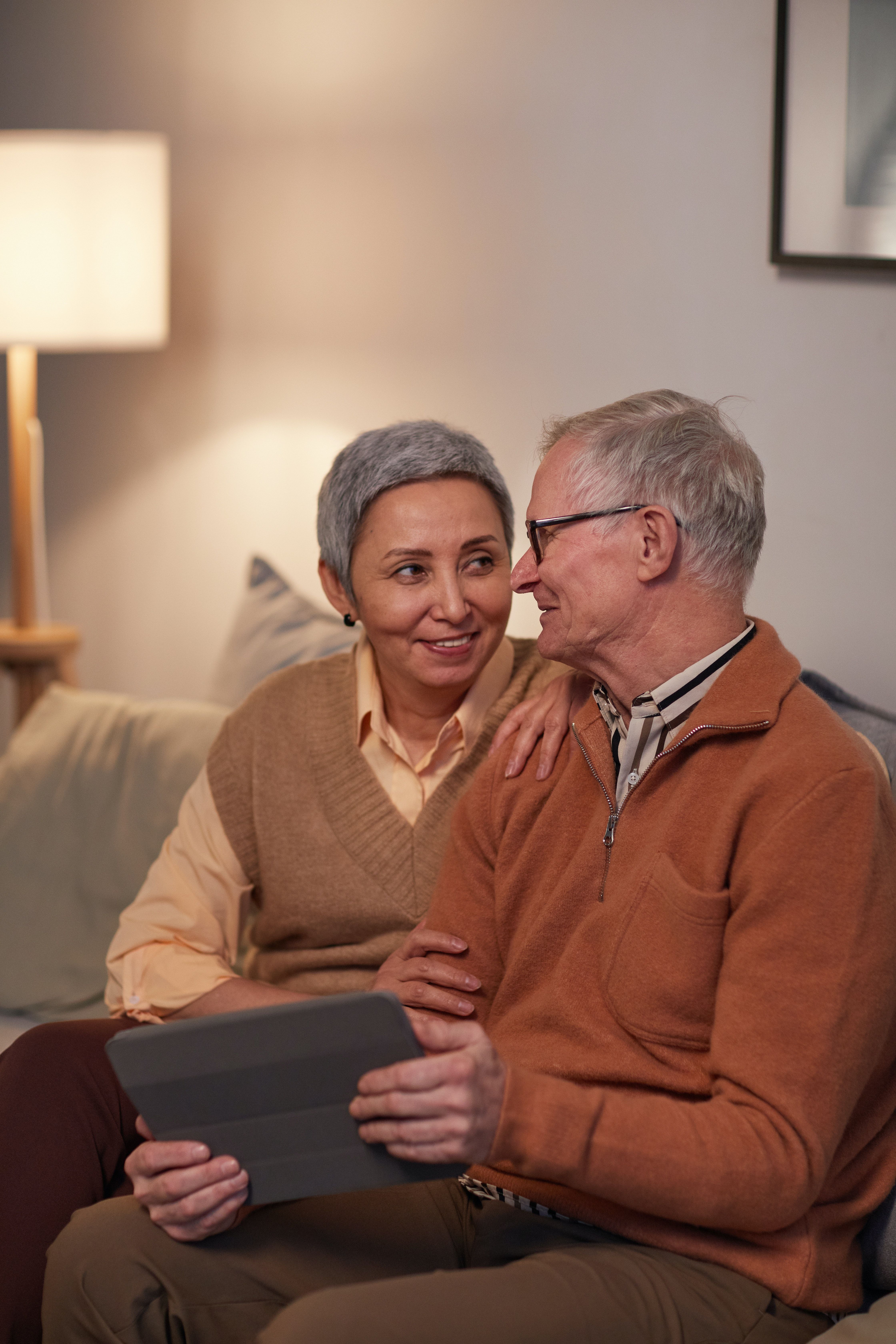 Older couple sitting on couch looking at picture frame