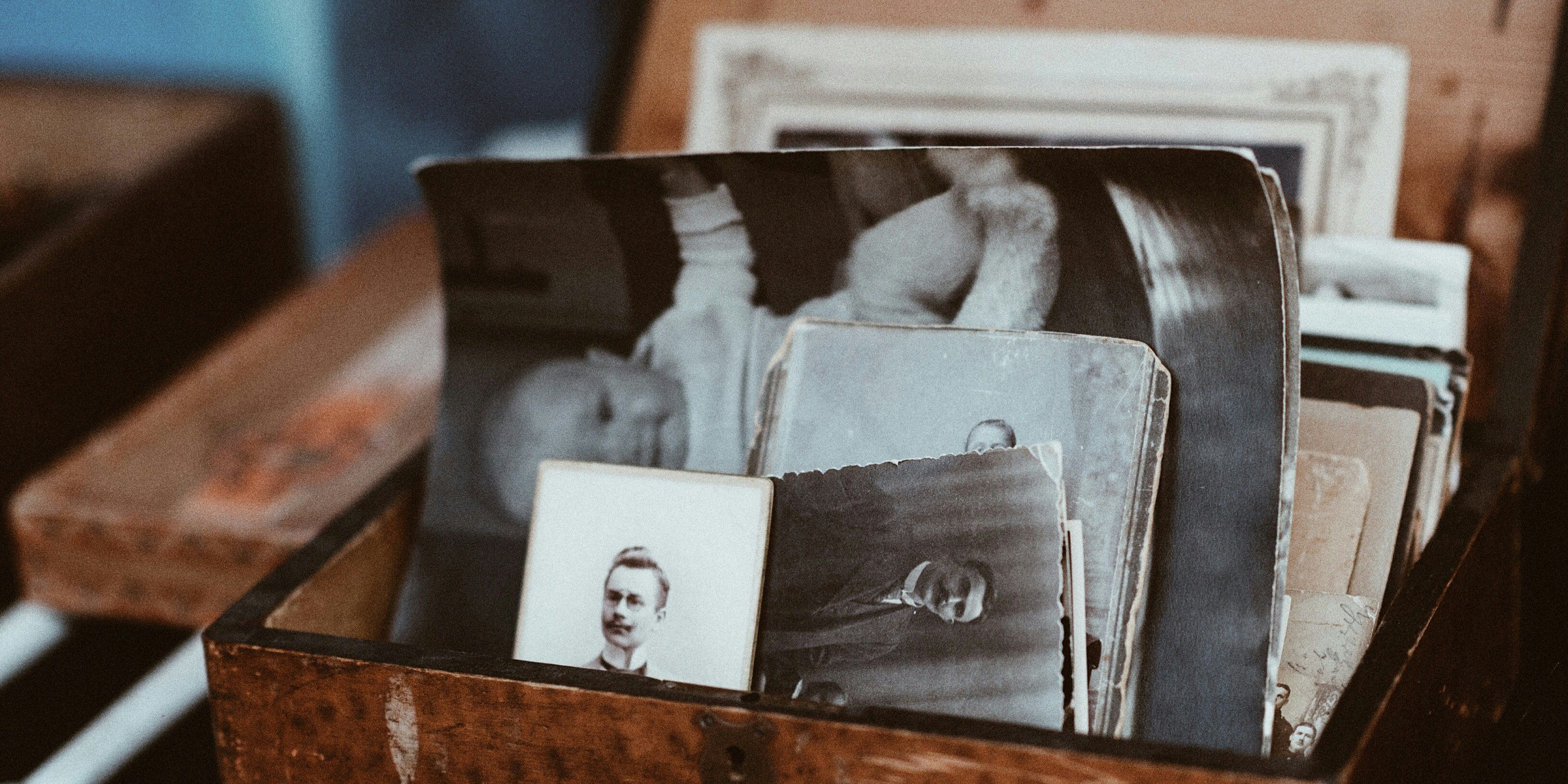 A wooden box filled with old black and white photos .