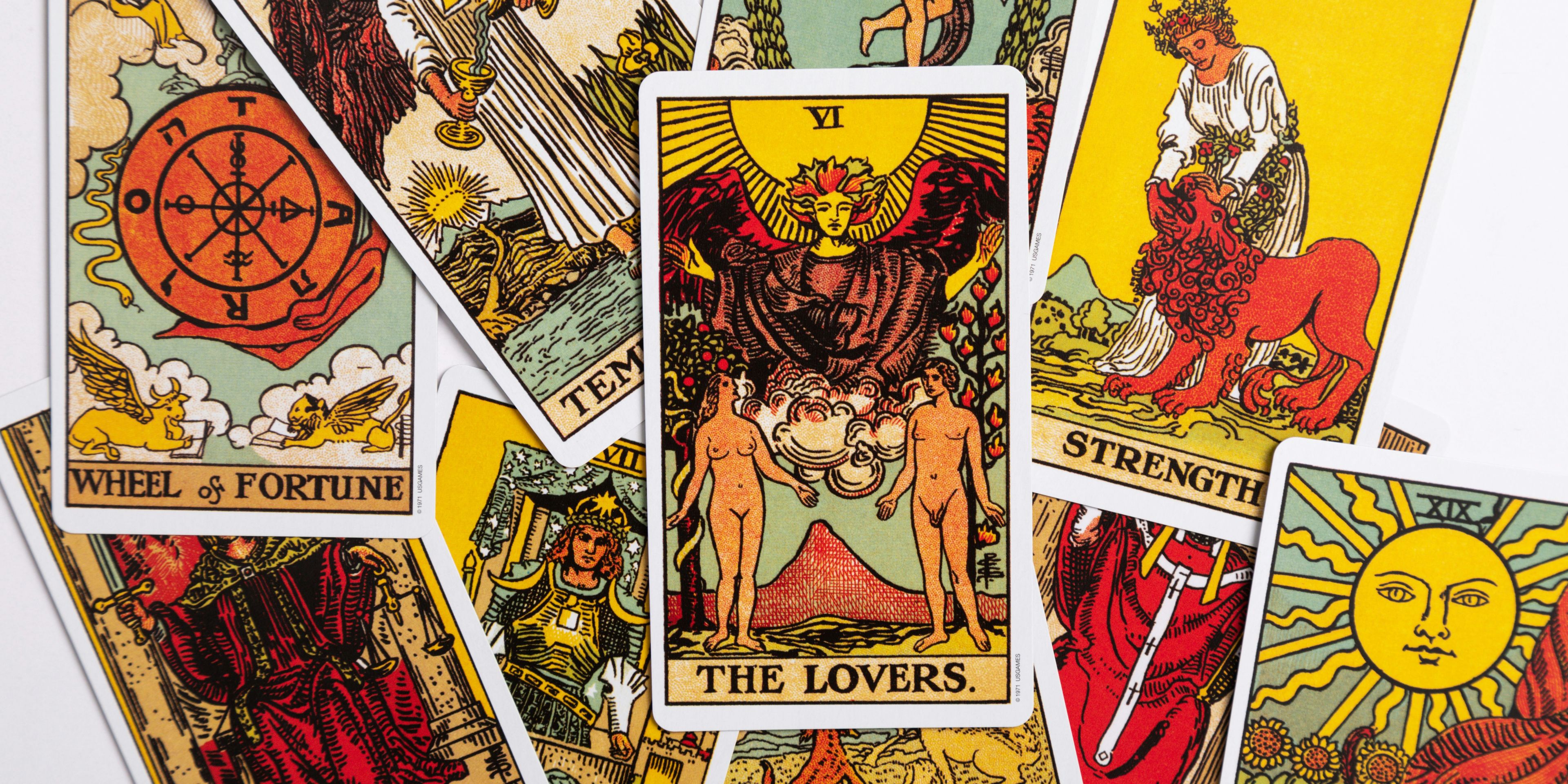 A bunch of tarot cards are stacked on top of each other on a table.