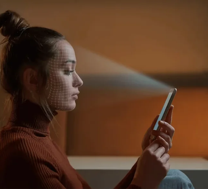 Mulher escaneando o rosto com o celular para verificar a identidade