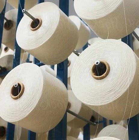Cones of white yarn mounted on a textile mill frame