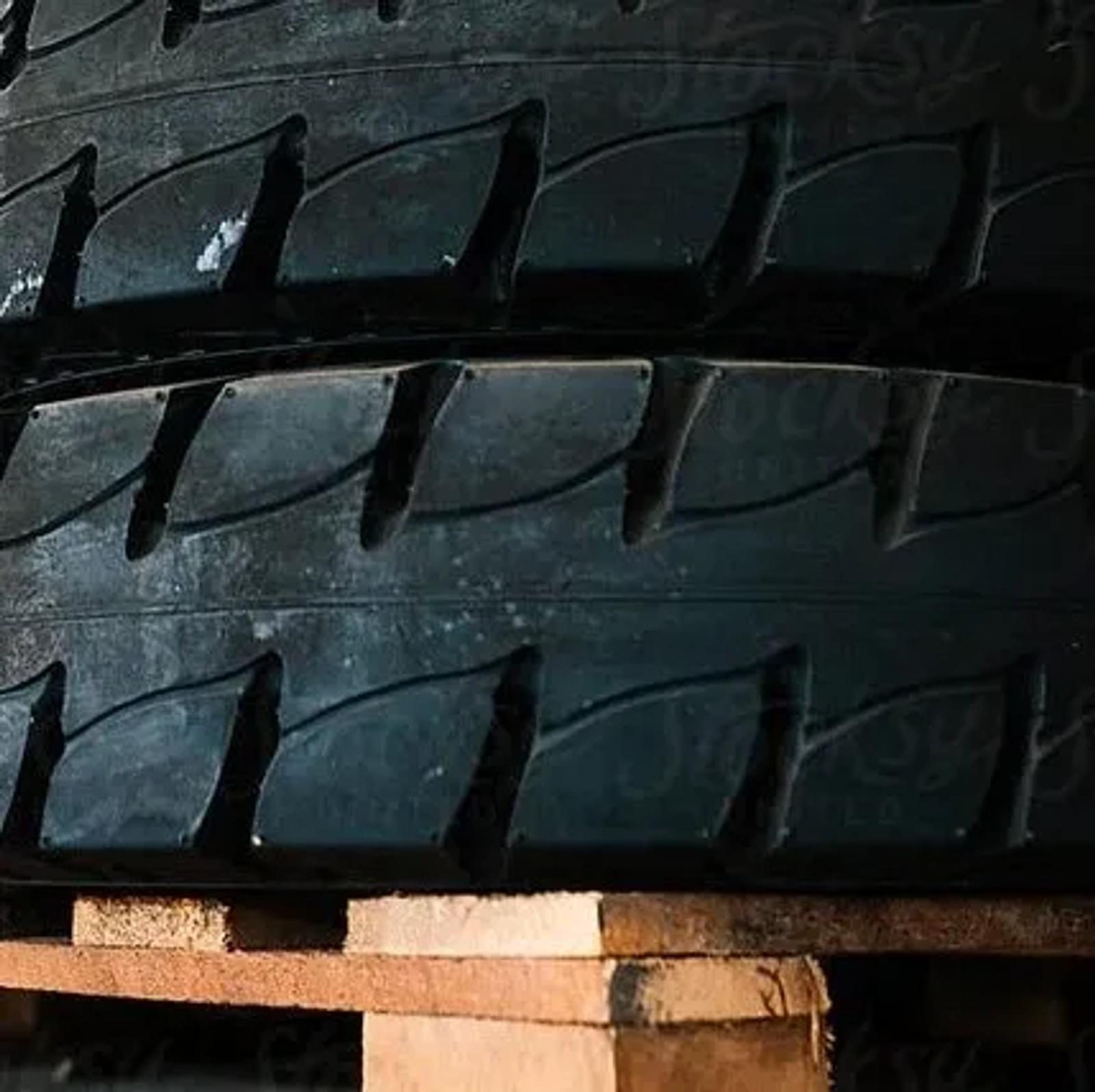 Close-up of stacked truck tyres resting on a wooden pallet