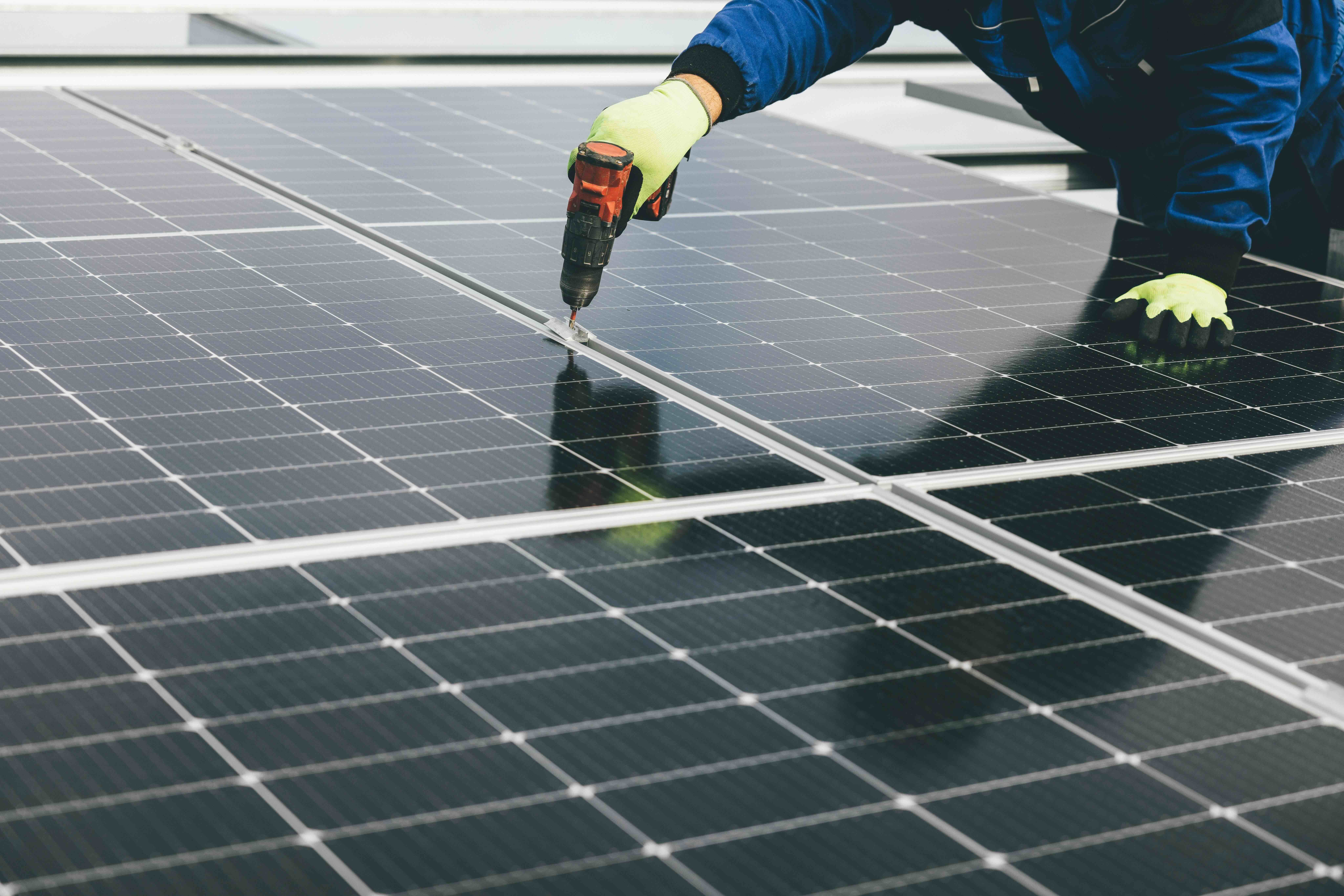 up close shot of a person building a solar panel, an industry that relies heavily on trade references and trade credit to operate