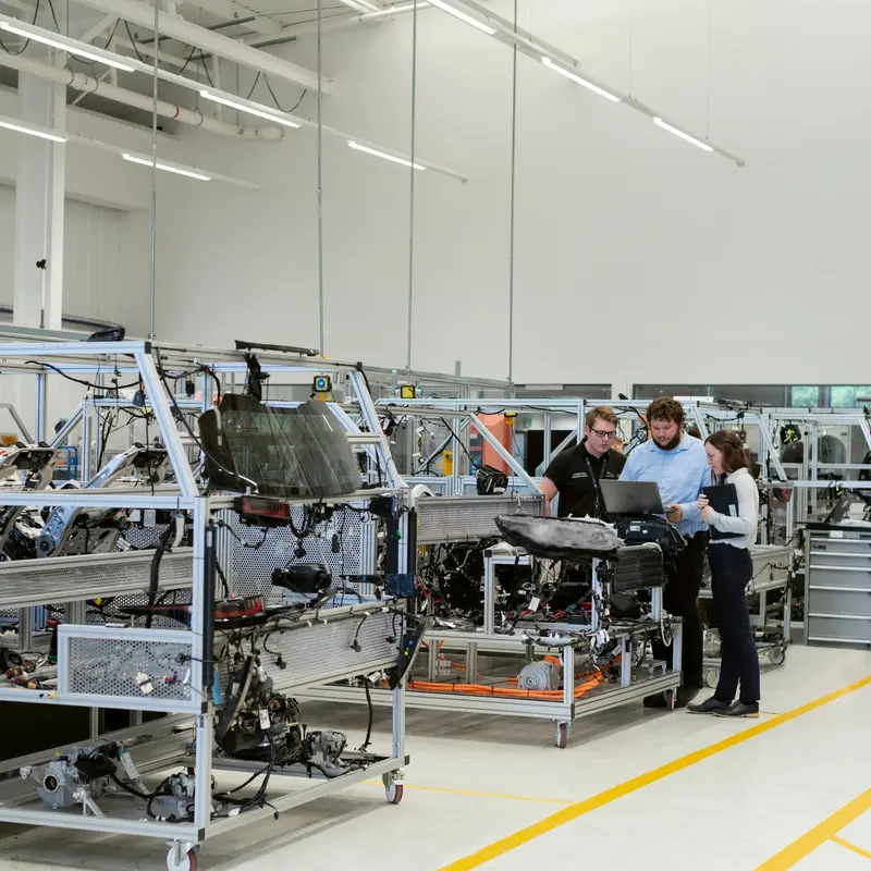Engineers assembling equipment on the floor of a manufacturing facility