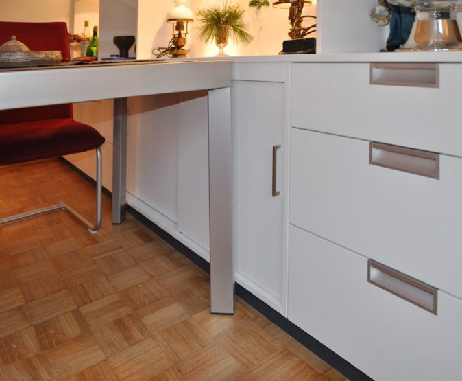 Weißer Einbau-Schreibtisch mit Schubladen und Griffmulden auf Parkettboden
