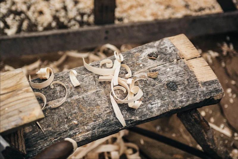 Geringelte helle Hobelspäne auf einem alten, verwitterten Holzbrett